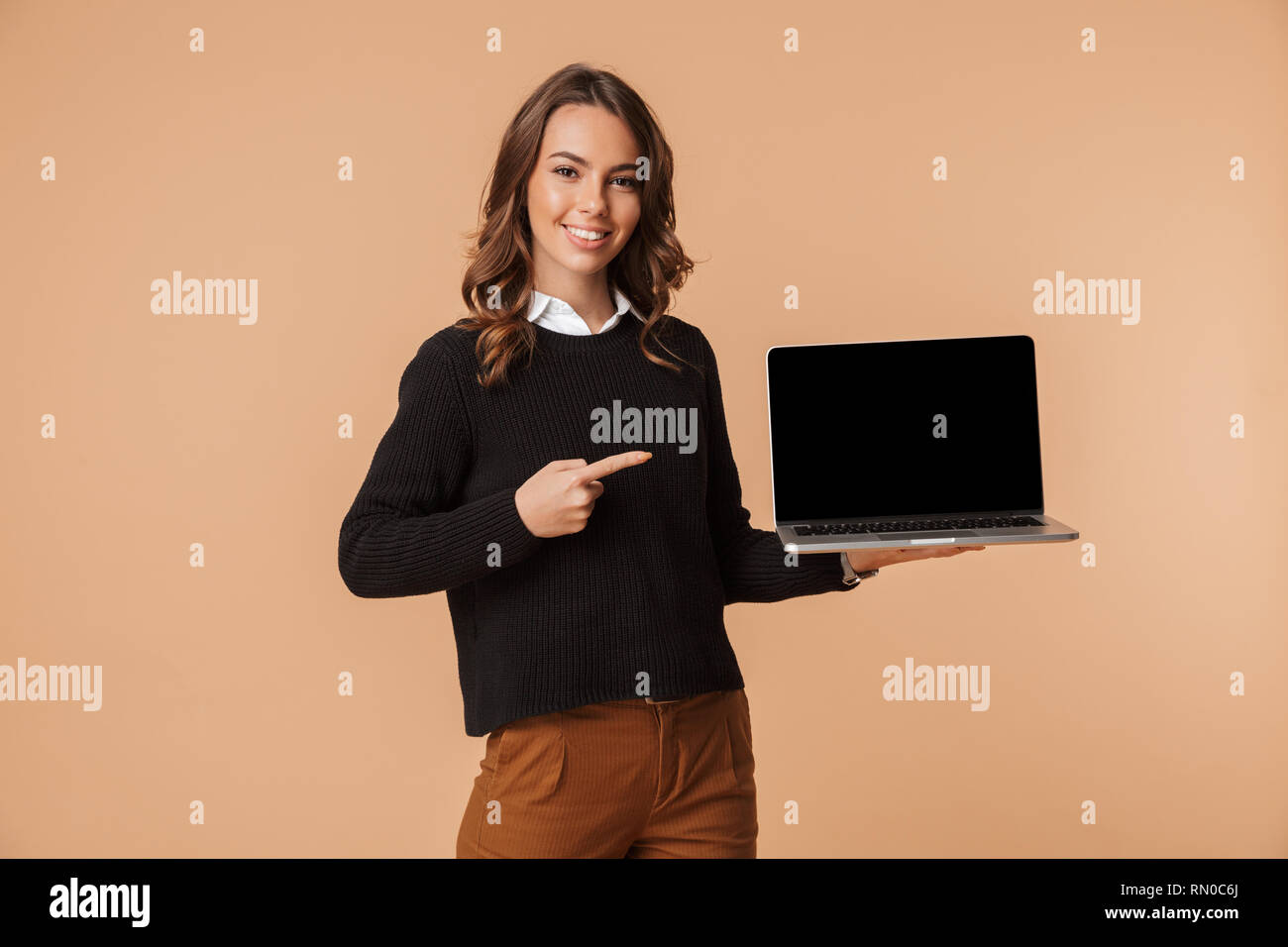 Happy young woman wearing sweater showing blank screen laptop computer ...
