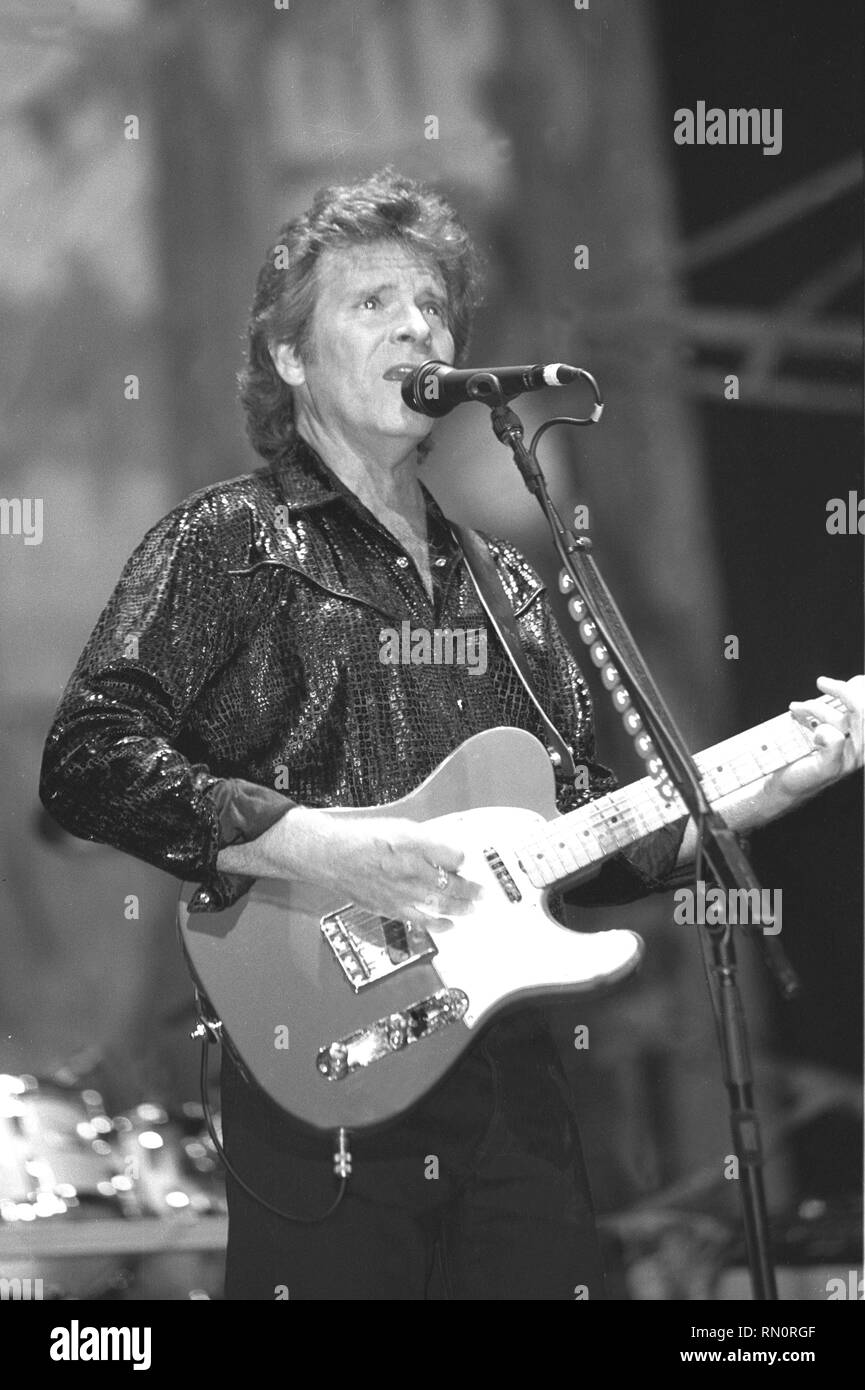 Singer, songwriter and guitarist John Fogerty is shown performing on stage during a live concert appearance. Stock Photo