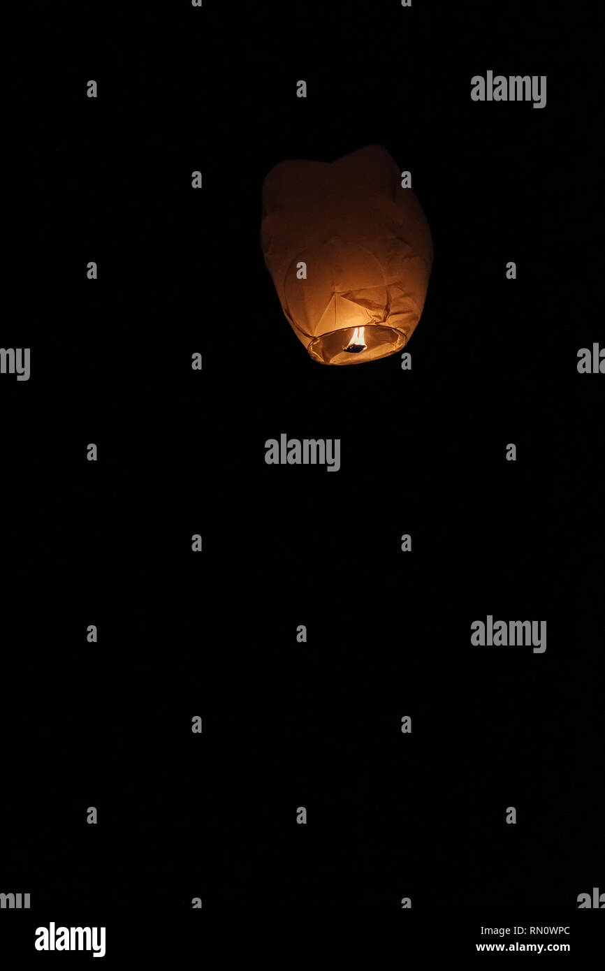 Sky lantern floating into the night sky at the festival in Pingxi, the Chinese text is a wish for money in New Year Stock Photo