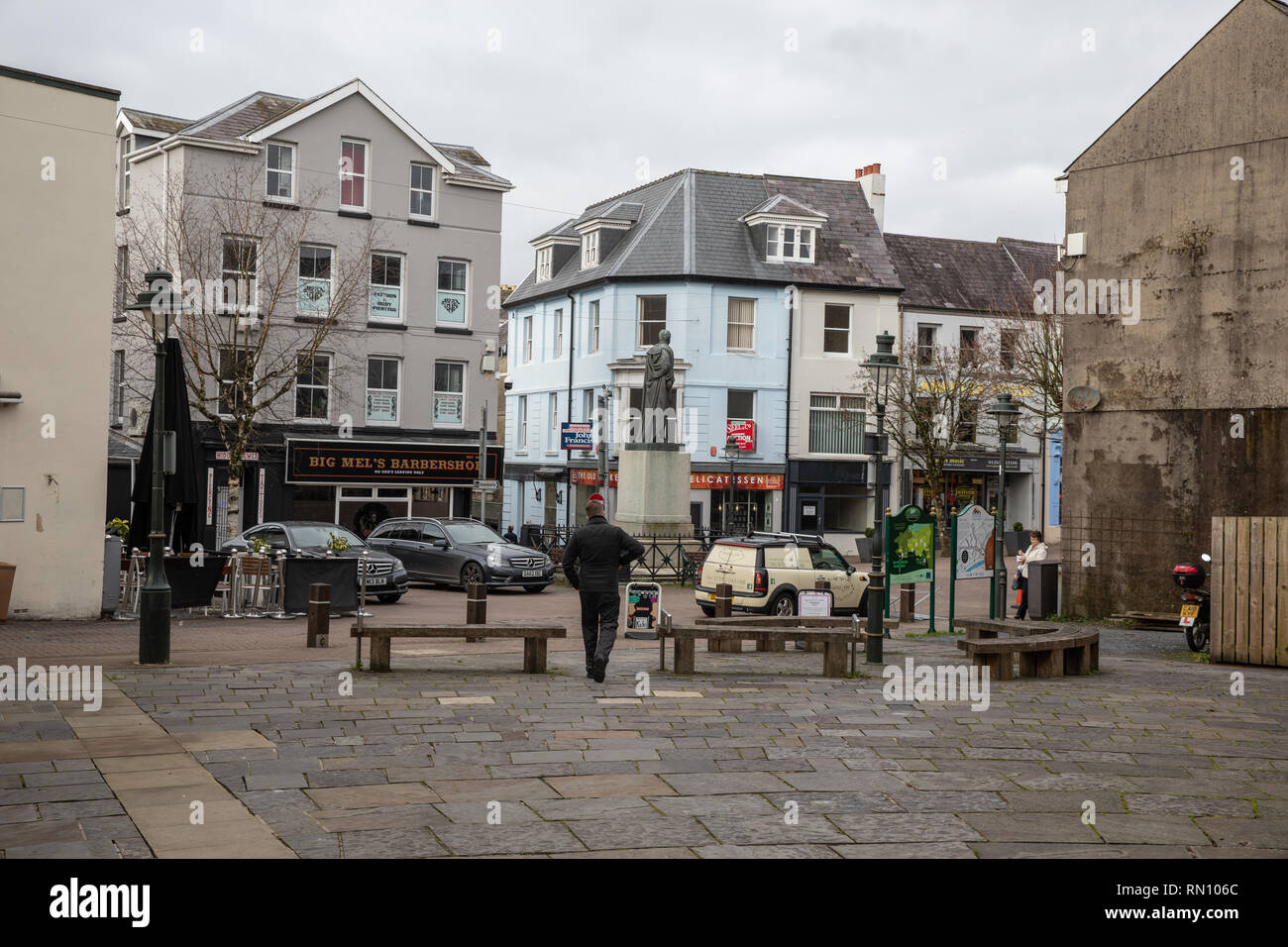 Typical view of Carmarthen Notts Square on a weekday.  Grey overcast weather and not many shoppers. Empty shops to let and parked cars. Stock Photo