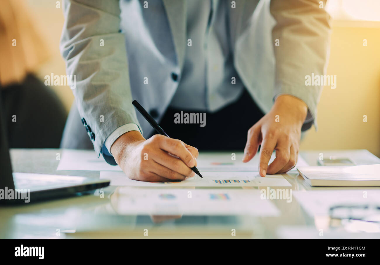 businessman investment consultant analyzing company financial report balance sheet statement working with digital graphs. Stock Photo
