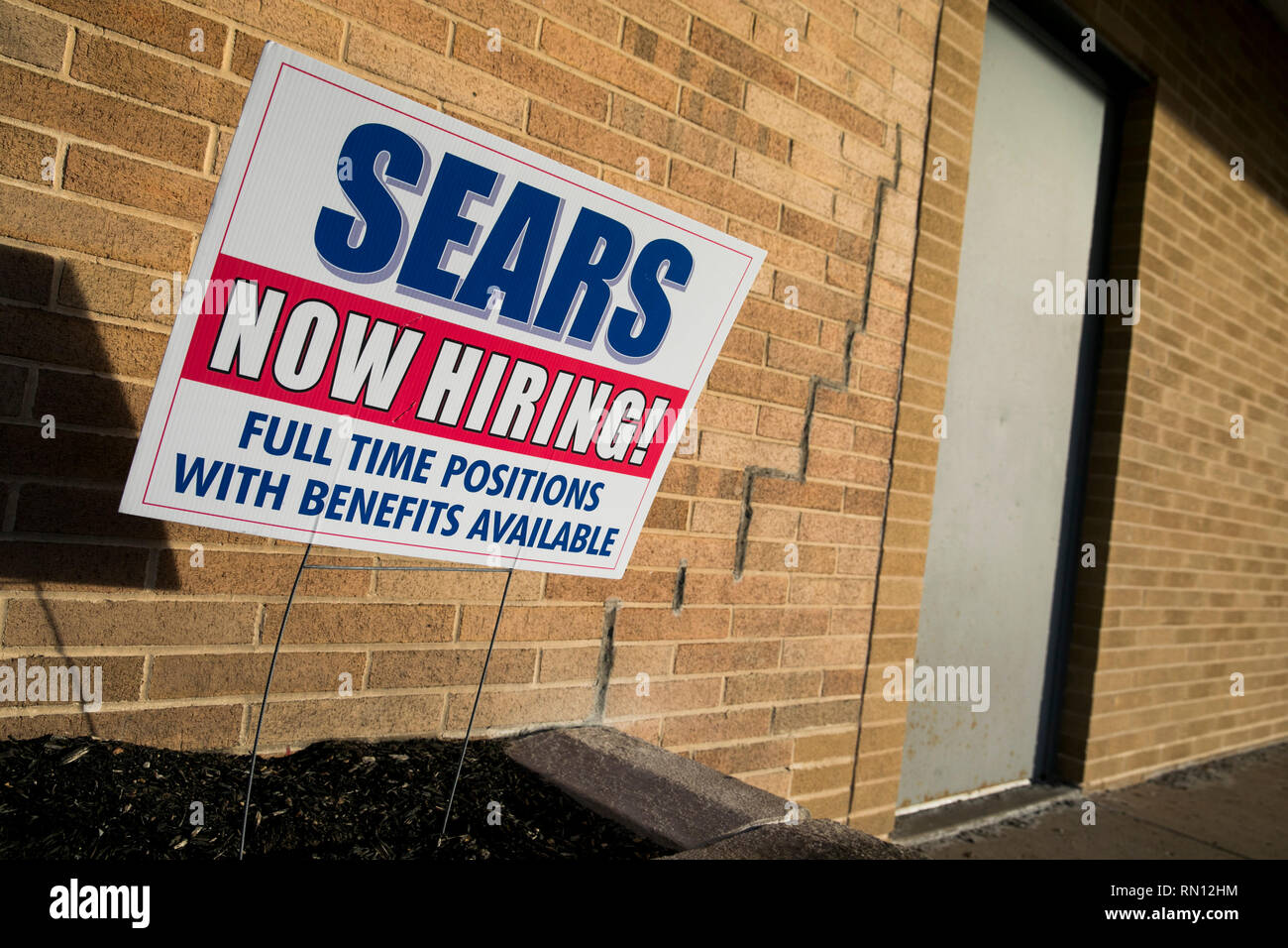 A 'Now Hiring' sign outside of a Sears retail store location in Harrisburg, Pennsylvania on February 9, 2019. Stock Photo