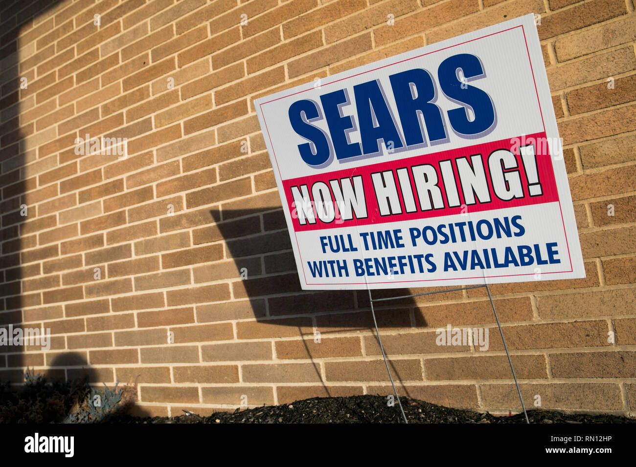 A 'Now Hiring' sign outside of a Sears retail store location in Harrisburg, Pennsylvania on February 9, 2019. Stock Photo