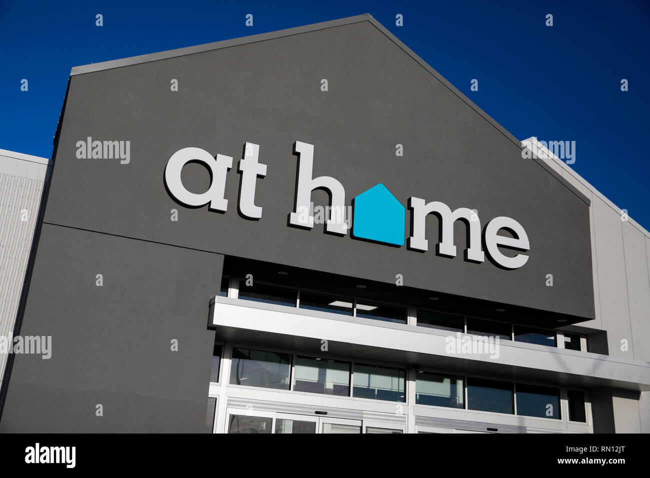 A logo sign outside of a At Home retail store location in Harrisburg, Pennsylvania on February 9, 2019. Stock Photo