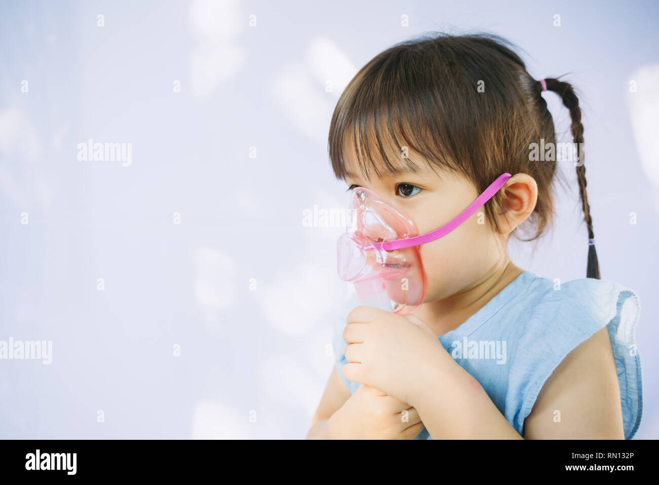 child who got sick by a chest infection after a cold or the flu that has trouble breathing and prolonged cough.A symptom of asthma or pneumonia. Stock Photo