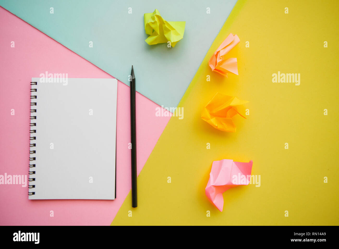 Blank notepad with place for text and a pencil on a multi-colored background. Stock Photo