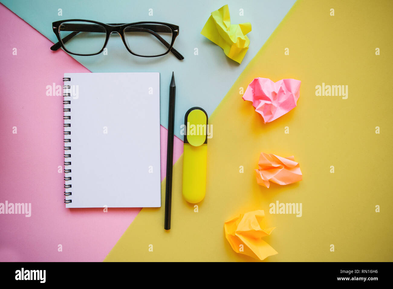 Blank notepad for text, glasses and other items on a multi-colored background. Stock Photo
