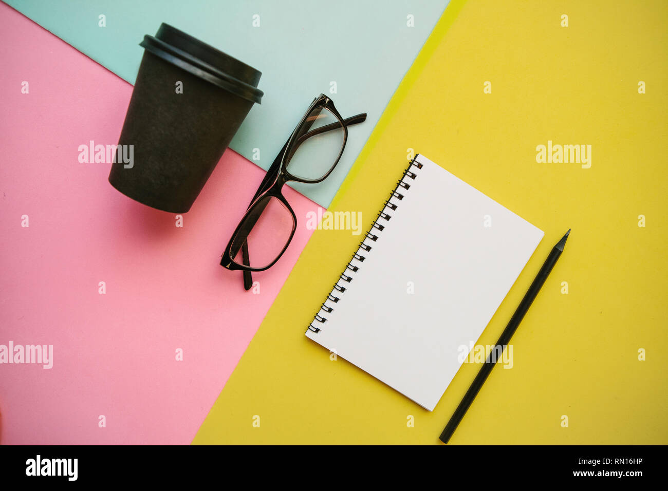 Notebook, glasses and other items on a colorful background. Stock Photo