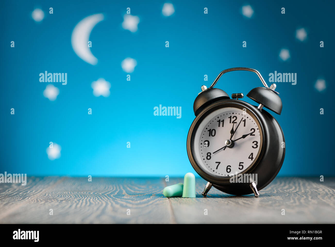 Earplugs and vintage alarm clock Stock Photo Alamy