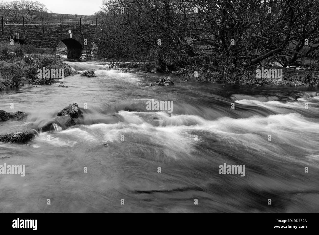 Black and white image of the River Lyd running under the B3357 on Dartmoor, landscape aspect with slow shutter speed Stock Photo