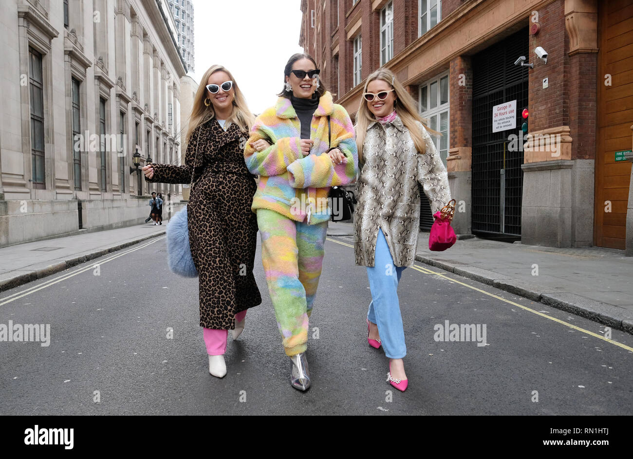 Fashion bloggers Olivia and Alice (left and right) and Natalia Homolova (centre) wear animal print and rainbow coord by Jaded London during the Autumn/Winter 2019 London Fashion Week outside Freemasons' Hall, London. Stock Photo