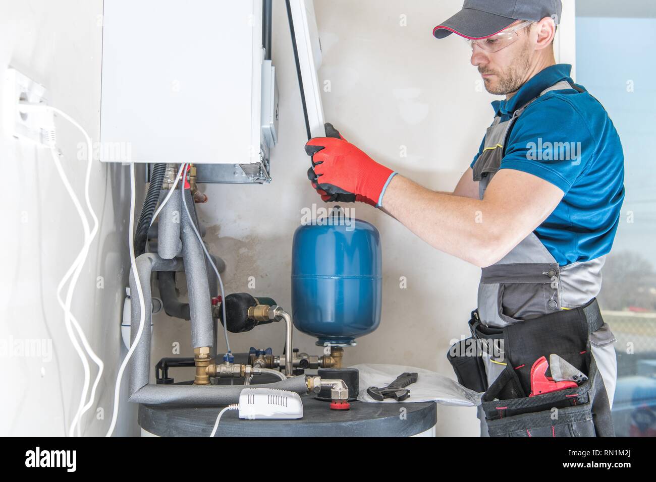 Central Gas Heater Installing by Professional Caucasian Heating Systems Installer Stock Photo