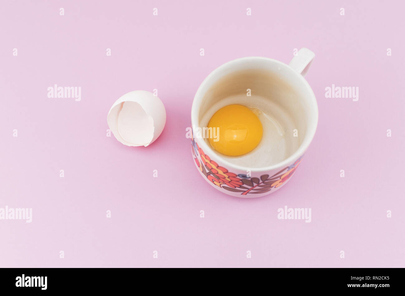 white empty broken egg shell and egg yolk in a cup Stock Photo