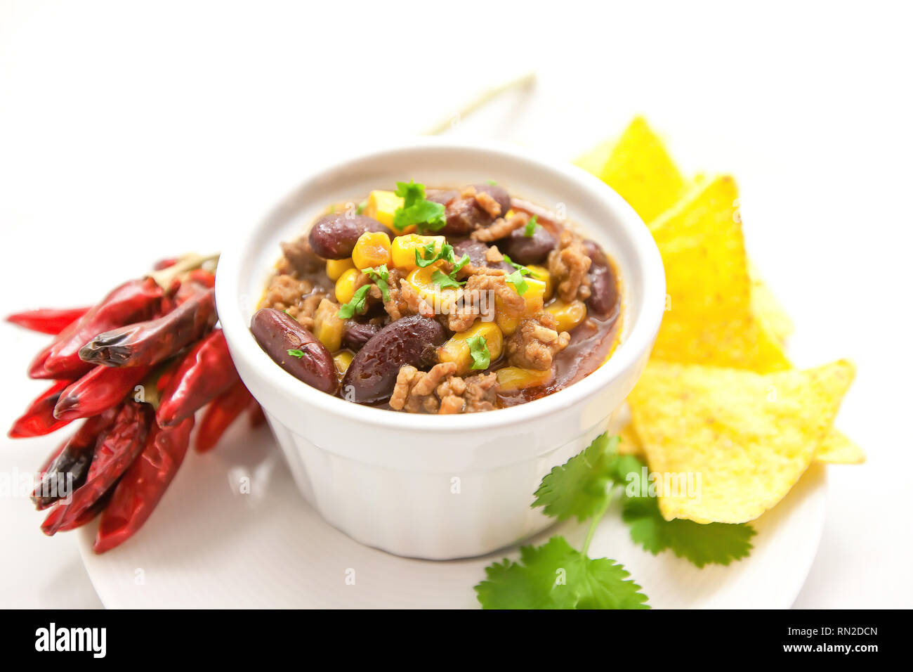 Chili con carne in a clay bowl on a white bright background