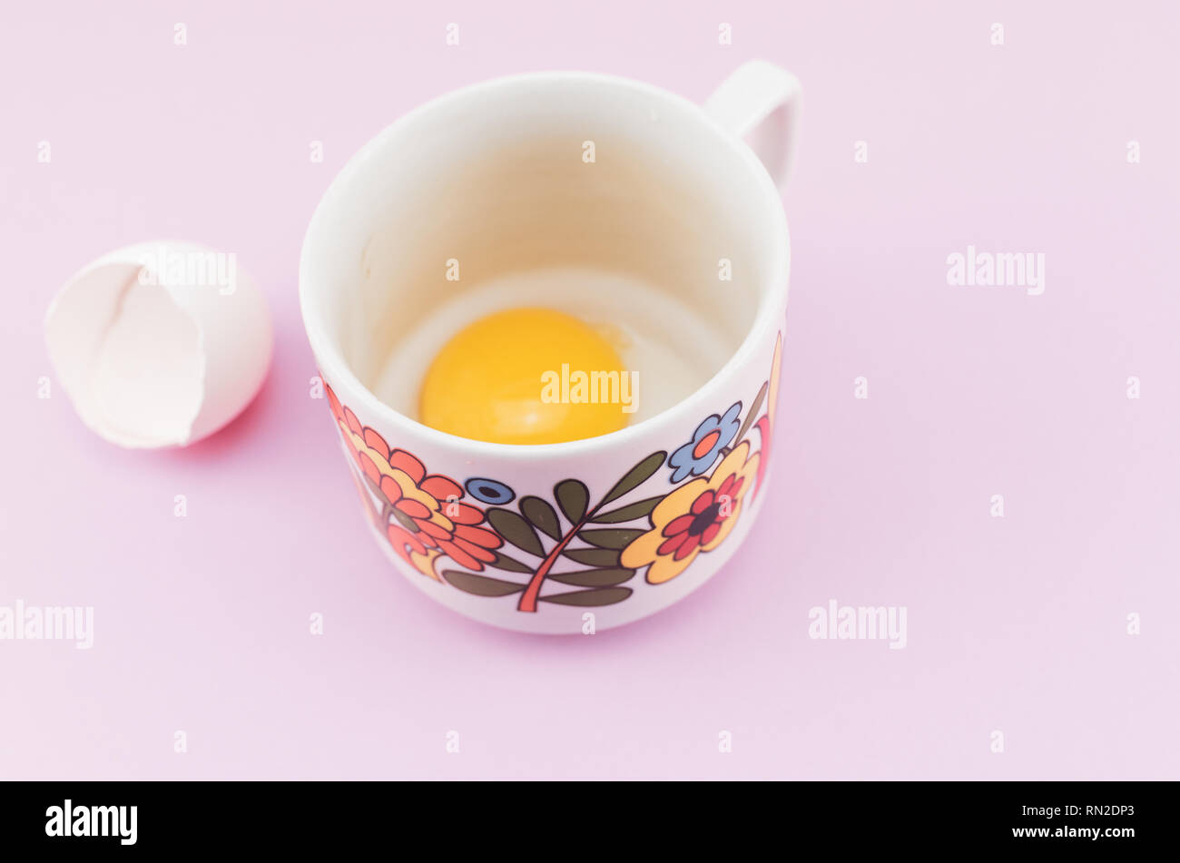 white empty broken egg shell and egg yolk in a cup Stock Photo