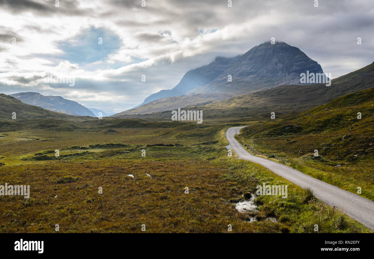 The A896 road meanders through the moorland valley floor of Glen Torridon, under the distinctive shaped Liathach mountain in the Torridon Hills of the Stock Photo