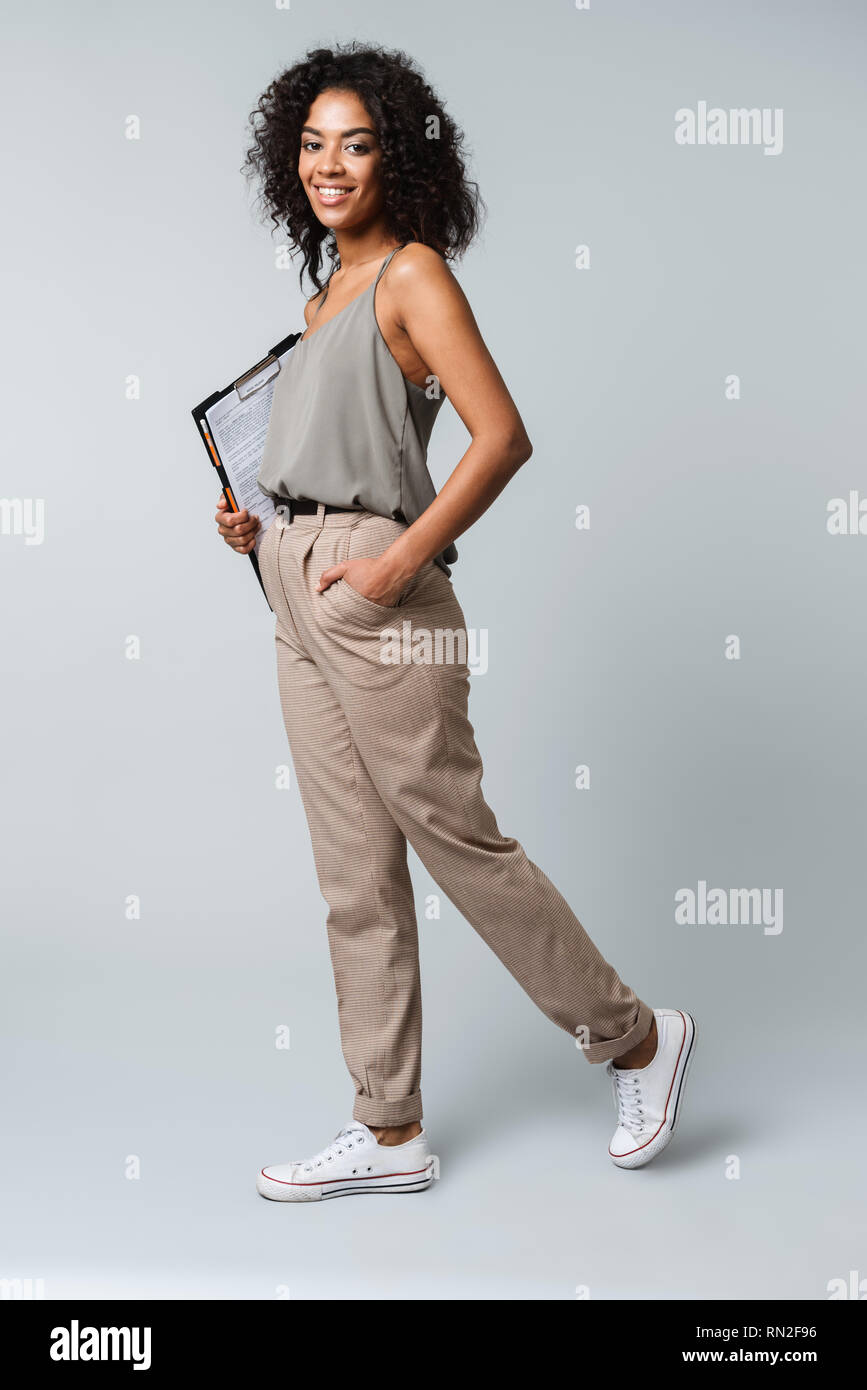 Full length of a happy young african woman casually dressed standing ...