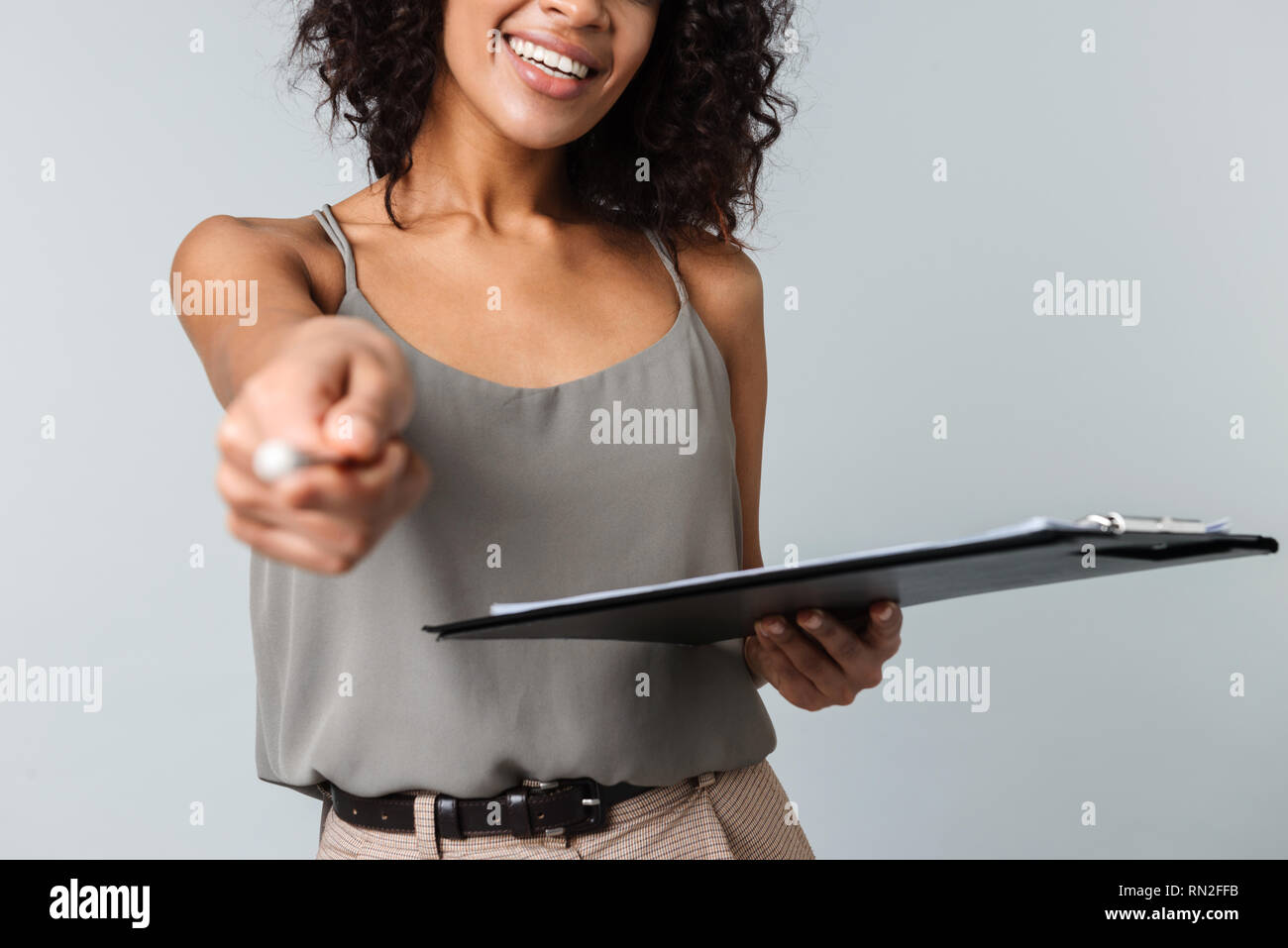 Cropped image of a happy young african woman casually dressed standing ...