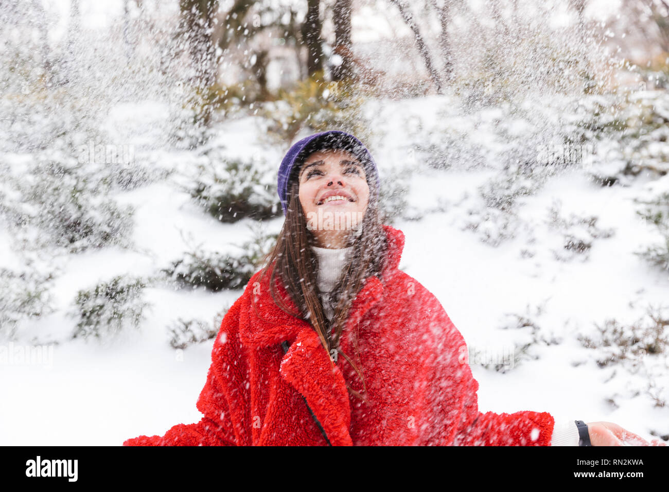 Image of a pretty young woman outdoors walking in snow winter park