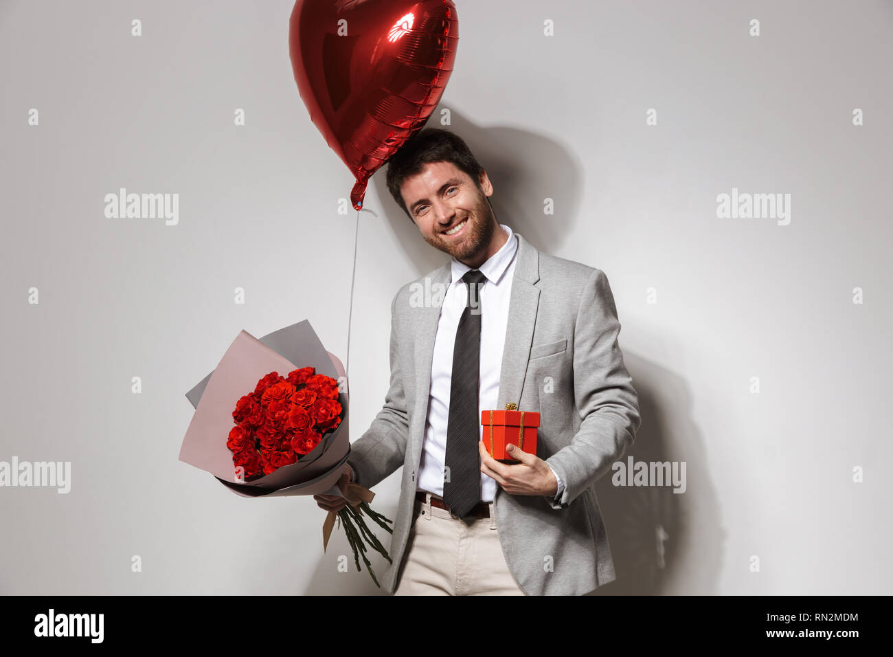 Portrait of a handsome confident young man wearing suit standing ...