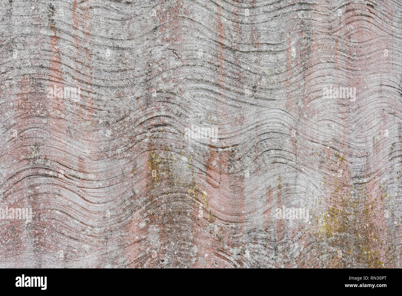 Abstract irregular wavy lines in cement rendered wall with light faded