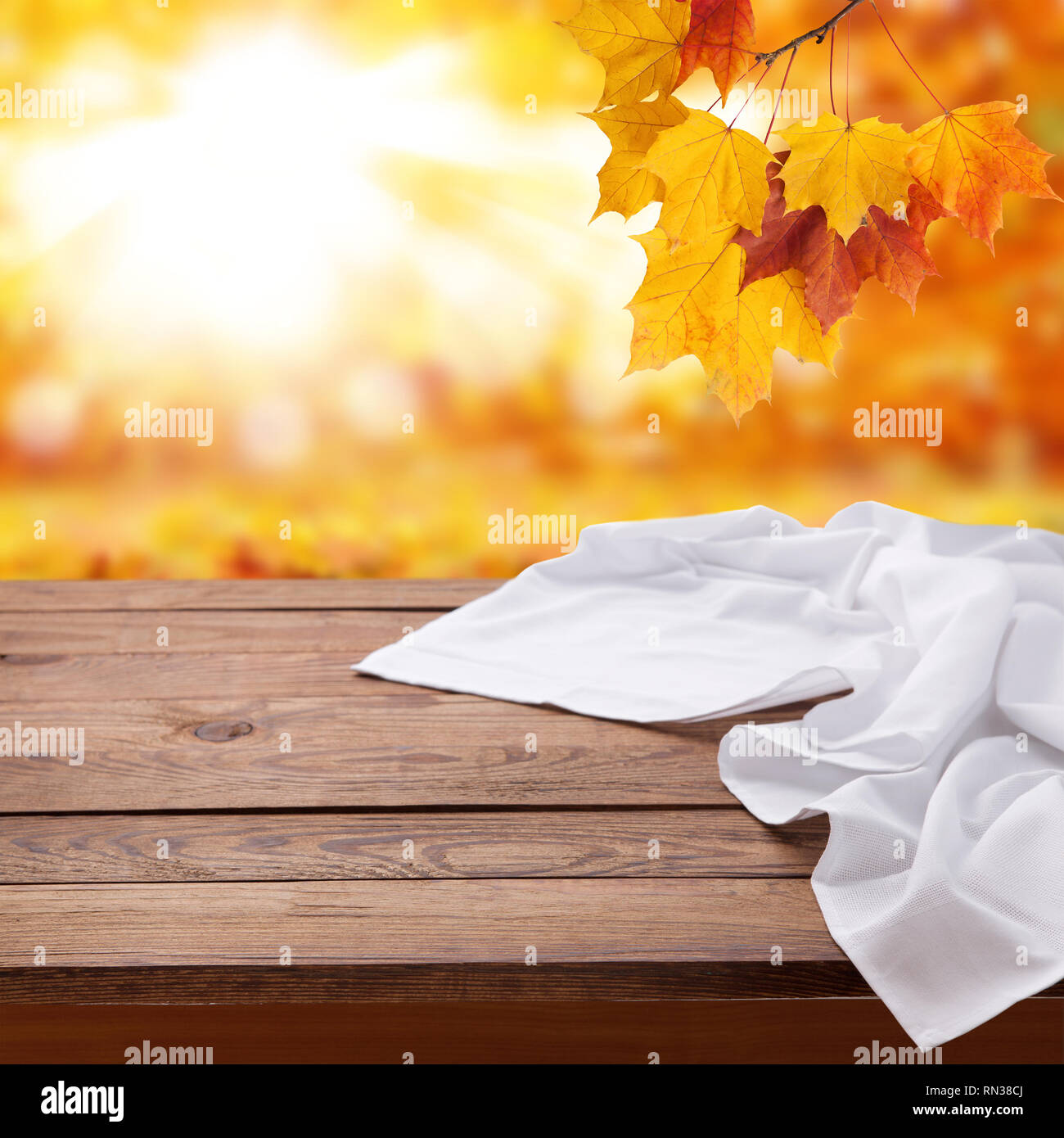 Autumn leaves background. Empty wooden deck table with white tablecloth ...