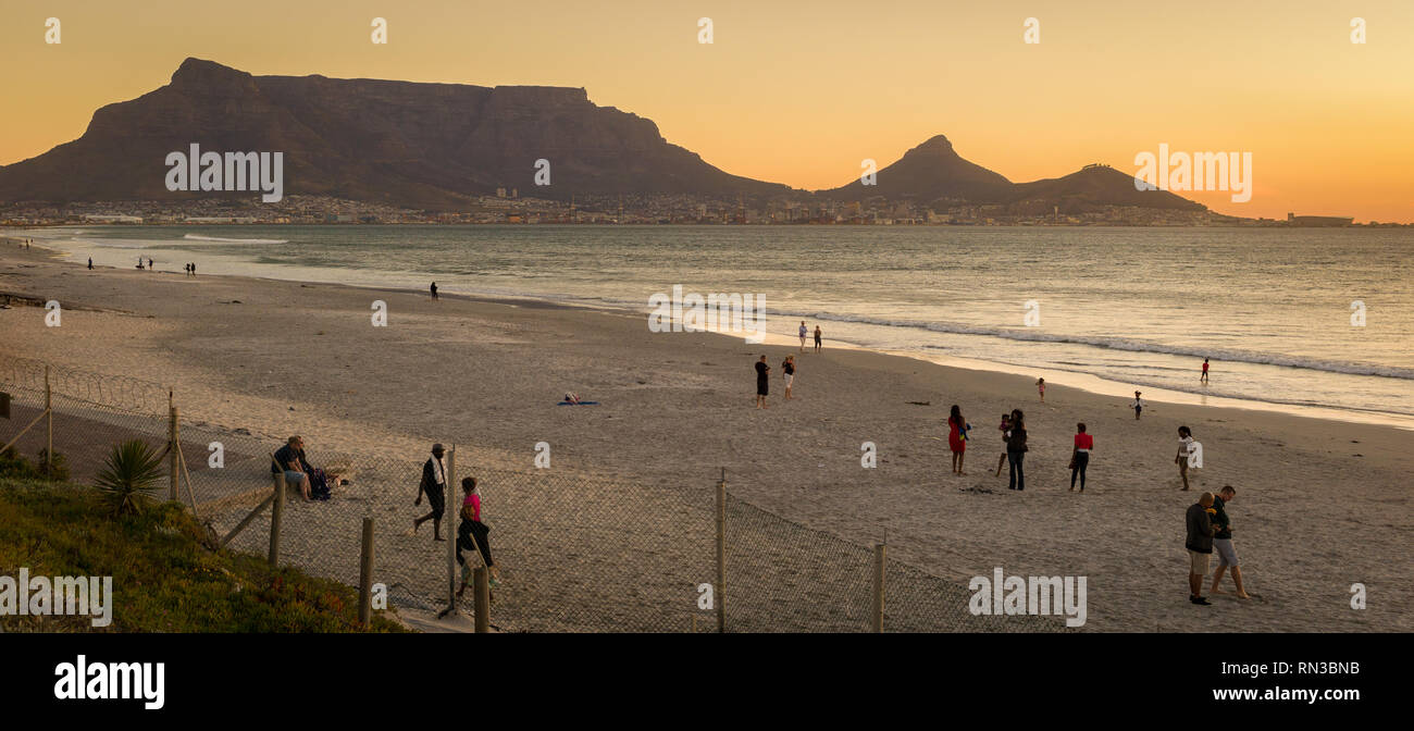 Cape Town has many beautiful beaches where visitors and locals alike enjoy a beach walk, like Sunset Beach, Cape Town, Western Cape, South Africa. Stock Photo