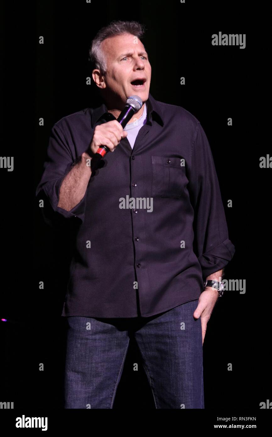 Comedian, actor, television personality, author and musician Paul Reiser is shown entertaining a sold out crowd during a 'live' comedy show. Stock Photo