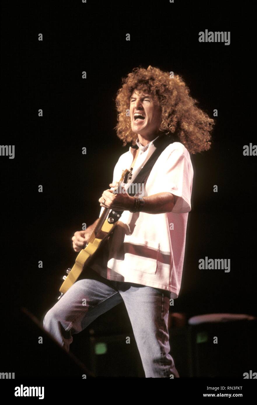 Singer and guitarist Kevin Cronin of the rock band REO Speedwagon is shown performing on stage during a 'live' concert appearance. Stock Photo