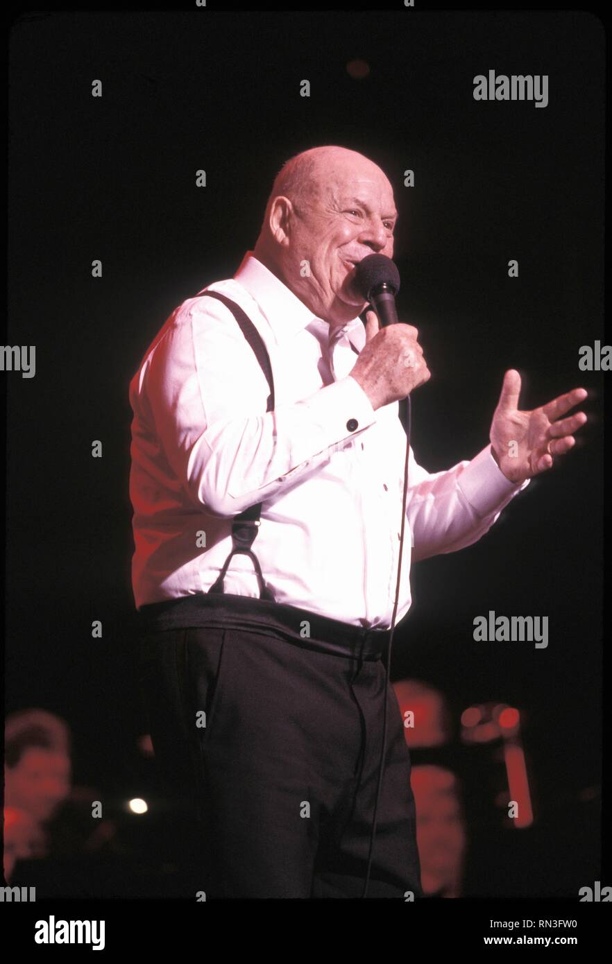Comedian Don Rickles is shown performing on stage during a “live