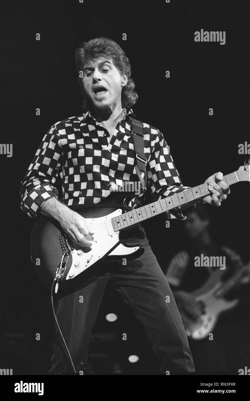 Musician Johnny Rivers is shown performing on stage during a "live