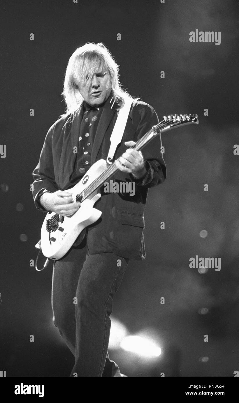 Guitarist Alex Lifeson is shown performing on stage during a “live