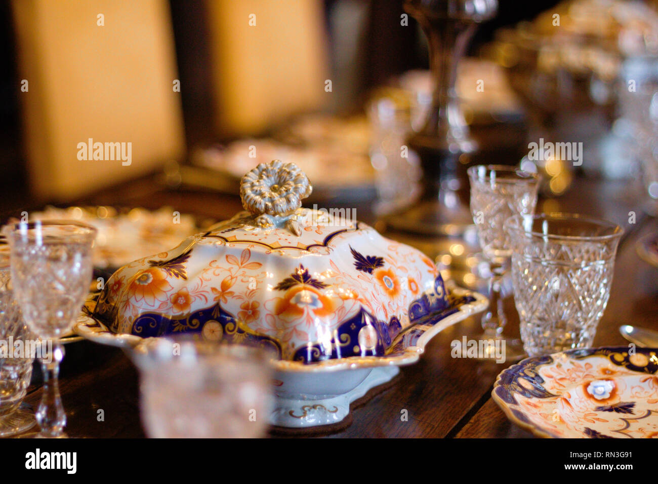 Porcelain and glasses on a antique laid table at Scotney castle in South England. Stock Photo
