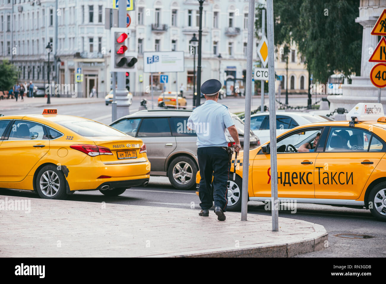 MOSCOW, RUSSIN FEDERATION - JULY 28, 2017: The inspector policeman stopped Yandex taxi driver, in Moscow in Russia during summer season - Image Stock Photo