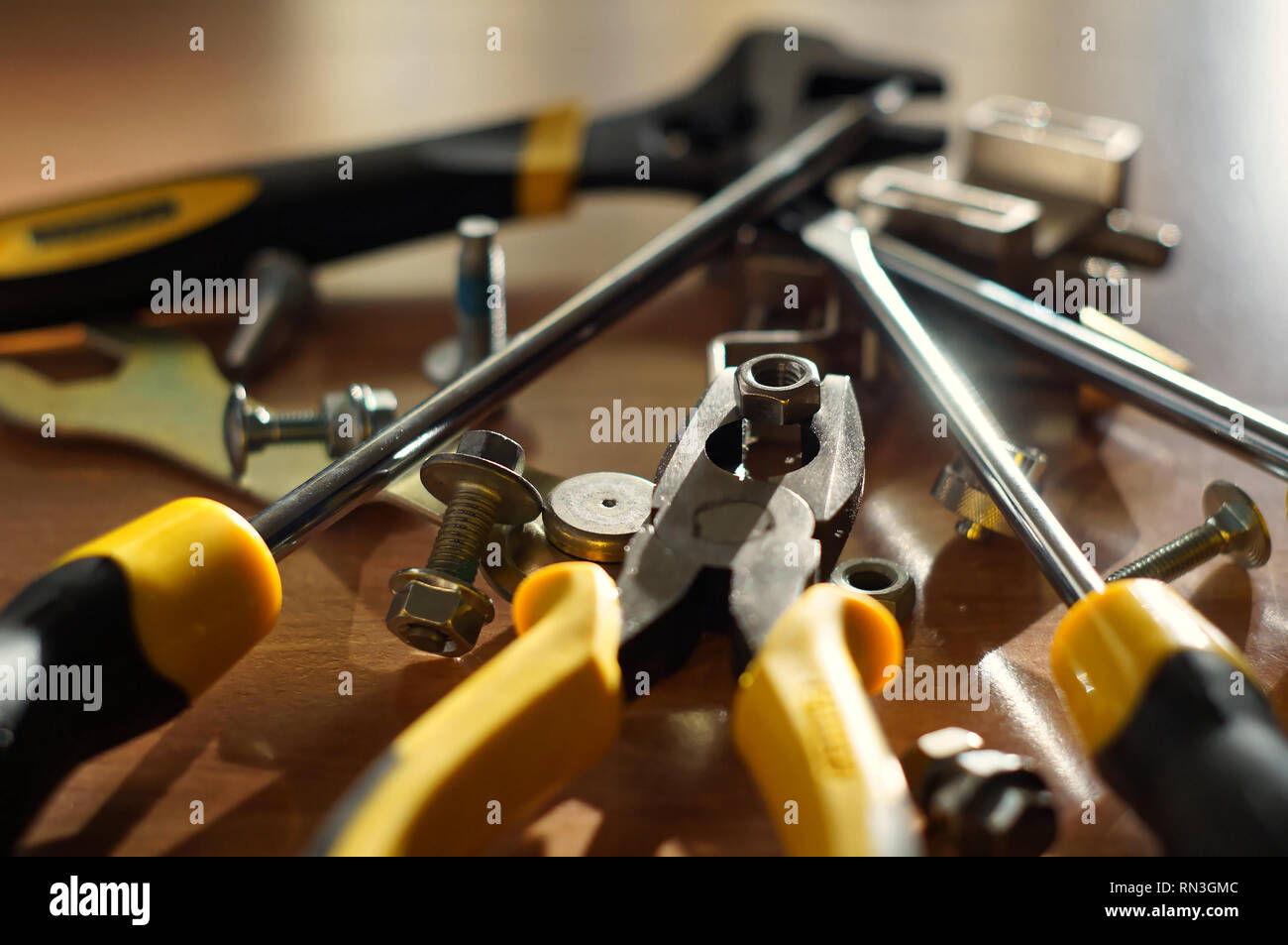 Do It Yourself DIY accessories - locksmith tools, wrenches, screwdrivers, pliers, nuts and bolts on a wooden table Stock Photo