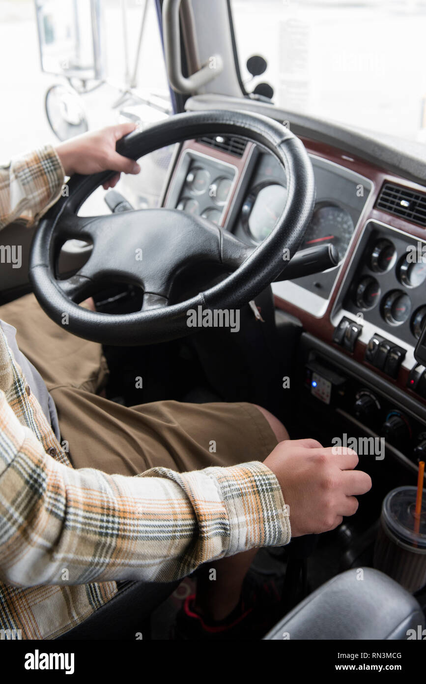 Hands of truck driver operating semi-truck Stock Photo