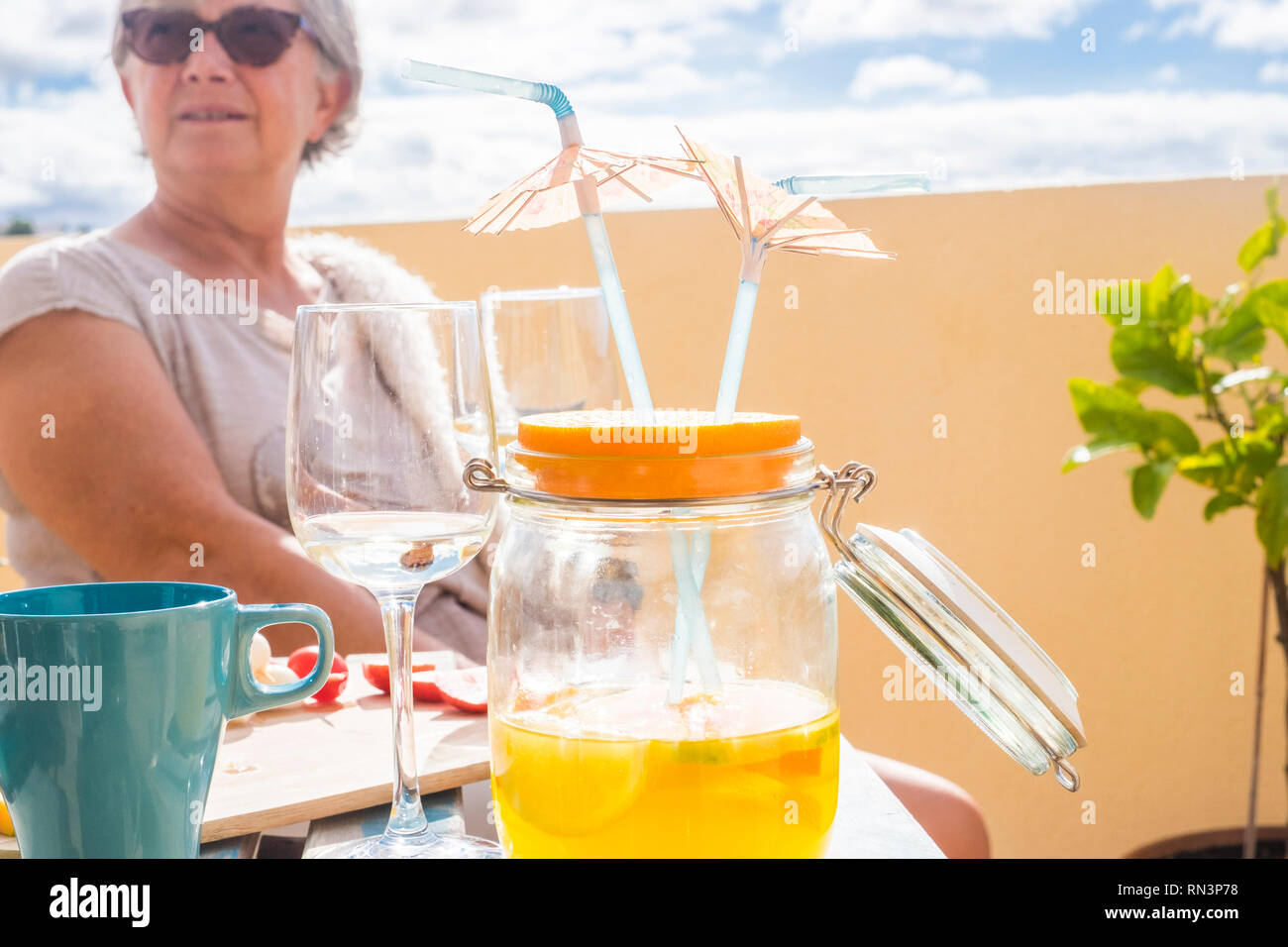Closeup of fresh seasonal juice fruit perfect for healthy lifestyle and diet - summer holiday vacation concept - aged lady with white hair and sunglas Stock Photo