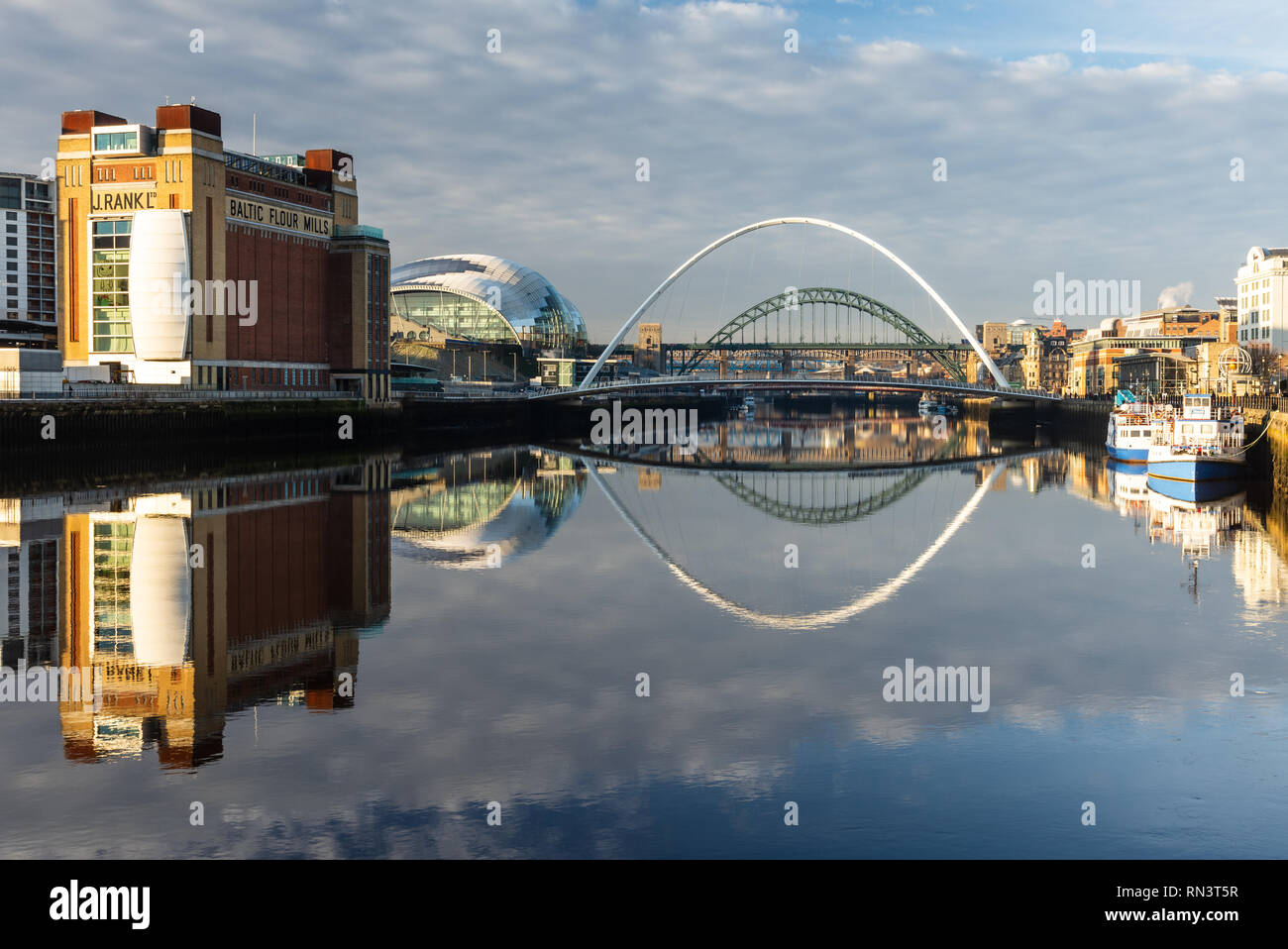 Gateshead, England, UK - February 5, 2019: Dawn light falls on the iconic Baltic Flour Mills building, Tyne Bridge and Gateshead Millennium Bridge on Stock Photo