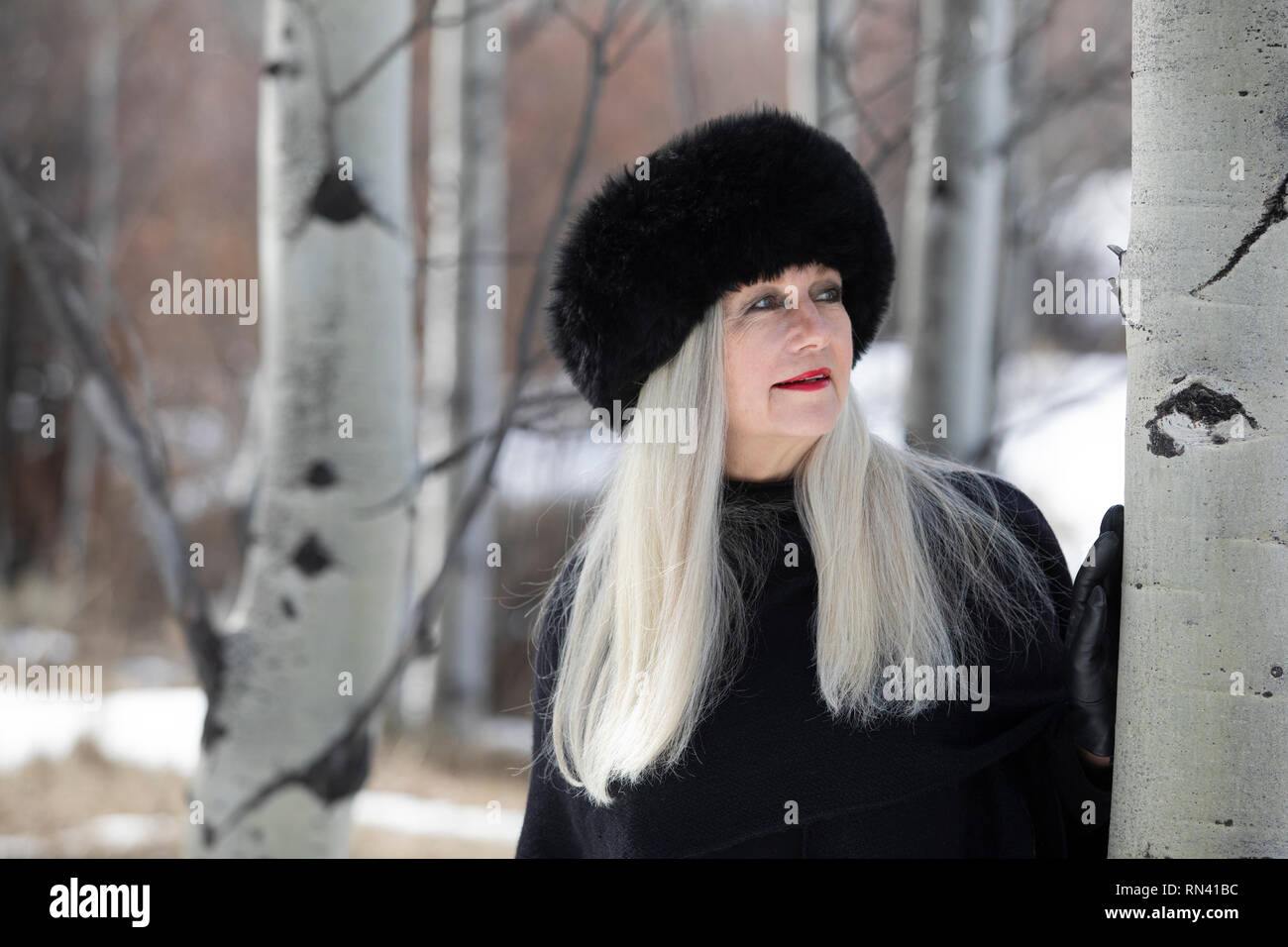 Woman with ushanka in forest Stock Photo