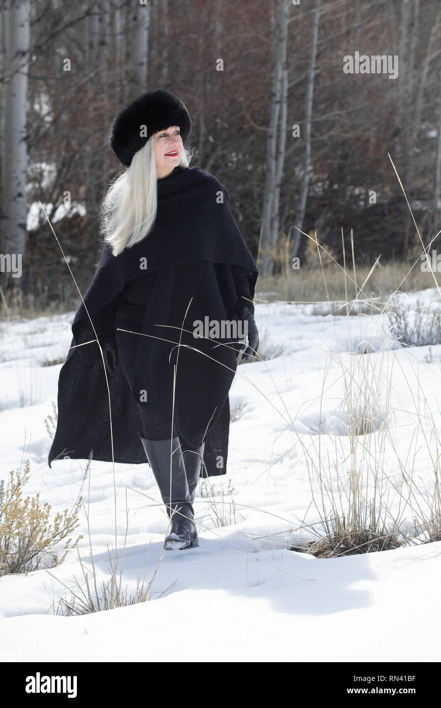 Woman with ushanka walking in snow Stock Photo