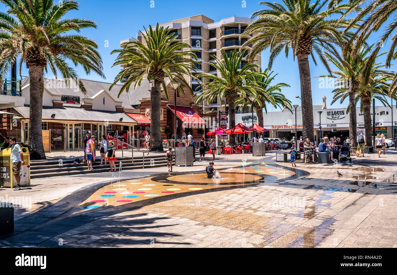 31st December 2018 , Glenelg Adelaide South Australia : Moseley square view on hot sunny summer day with kids playing in the water fountain in Glenelg Stock Photo