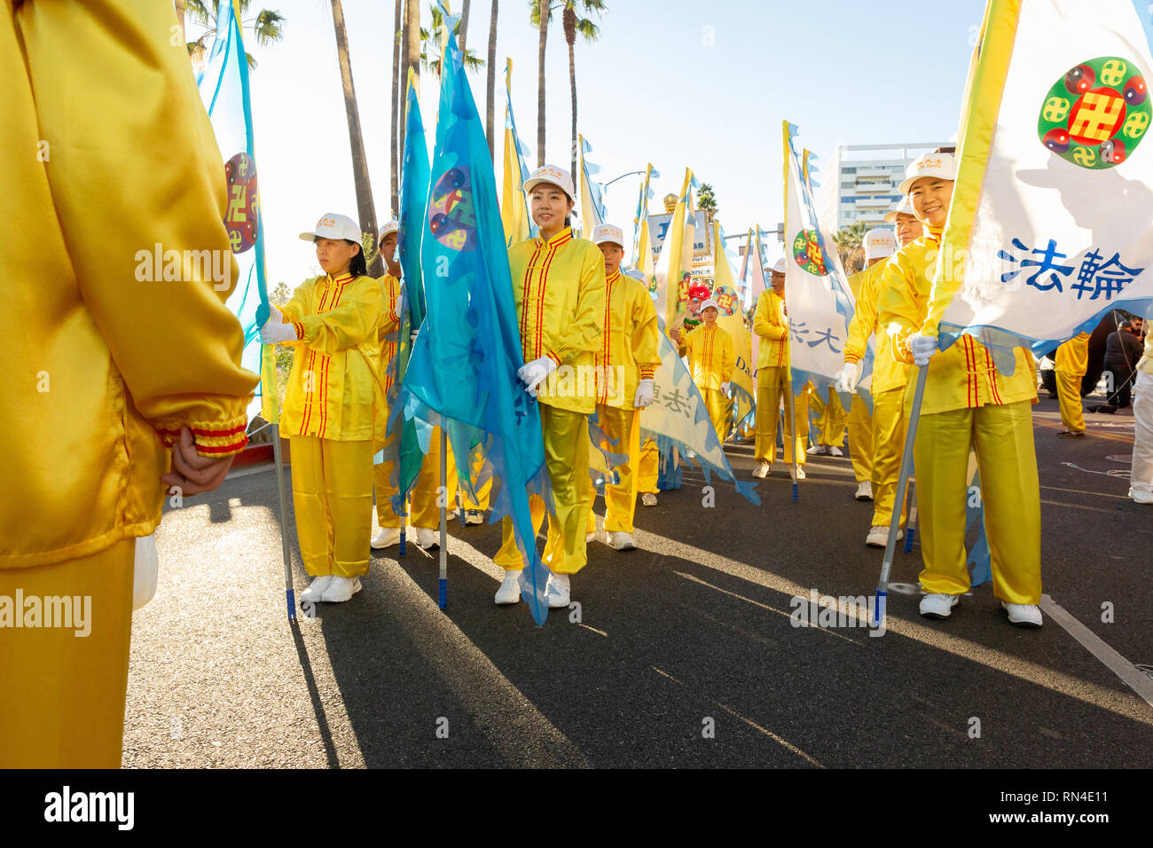 Falun Gong followers in bright yellow uniforms marching in Christmas