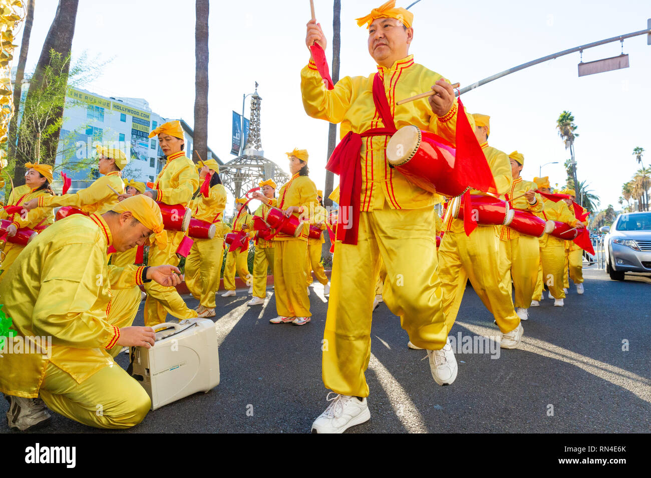 Falun Gong followers in bright yellow uniforms marching in Christmas