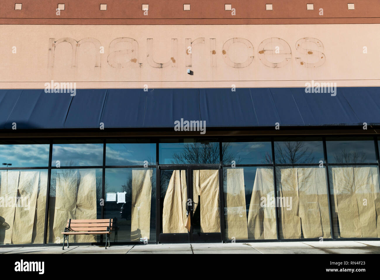 The outline of a logo sign outside of an abandoned Maurices retail