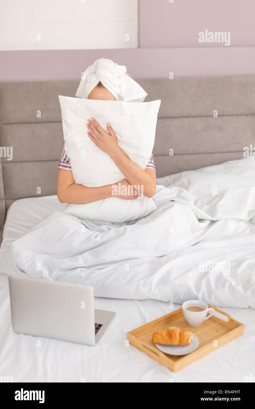 fearful woman hiding behind the pillow, close up photo.shame, offence