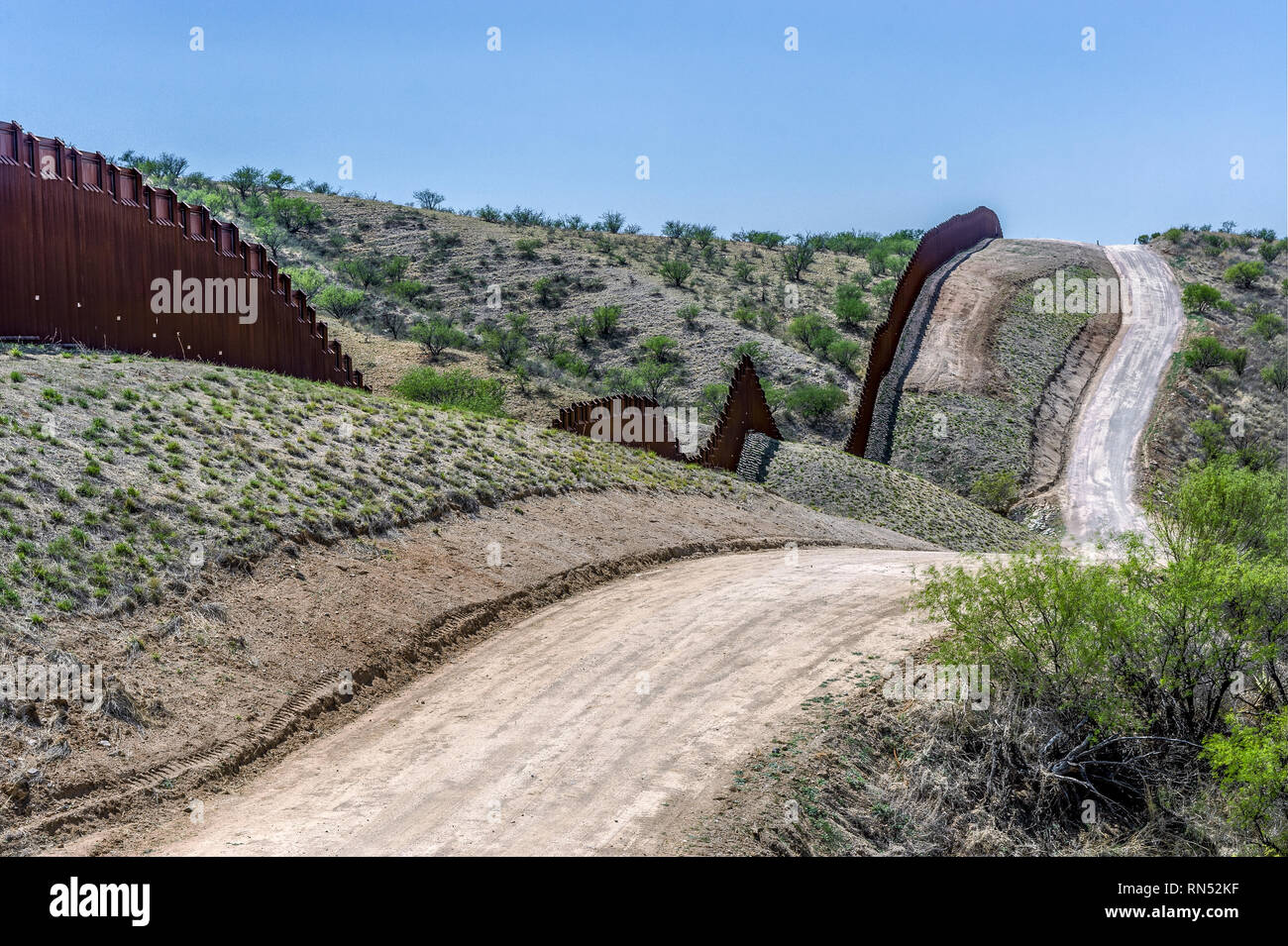 US border fence on Mexico boundary in hilly terrain, bollard pedestrian barrier, viewed from US side looking west, east of Nogales Arizona, April 2018 Stock Photo