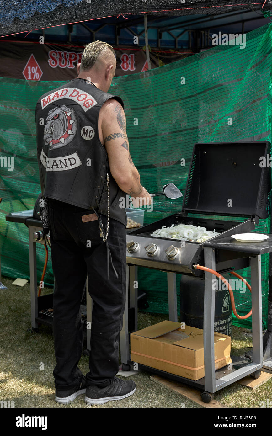 Man cooking. Biker cooking onions on a gas powered BBQ at a motorcycle event. Thailand Southeast Asia Stock Photo