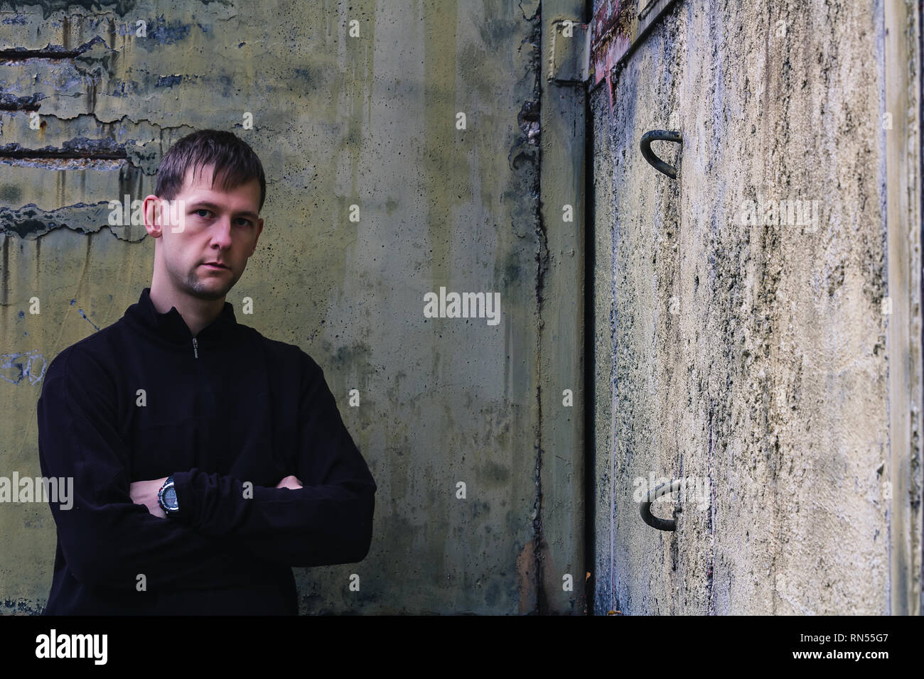 Portrait of young man stand in rough corner wall Stock Photo - Alamy