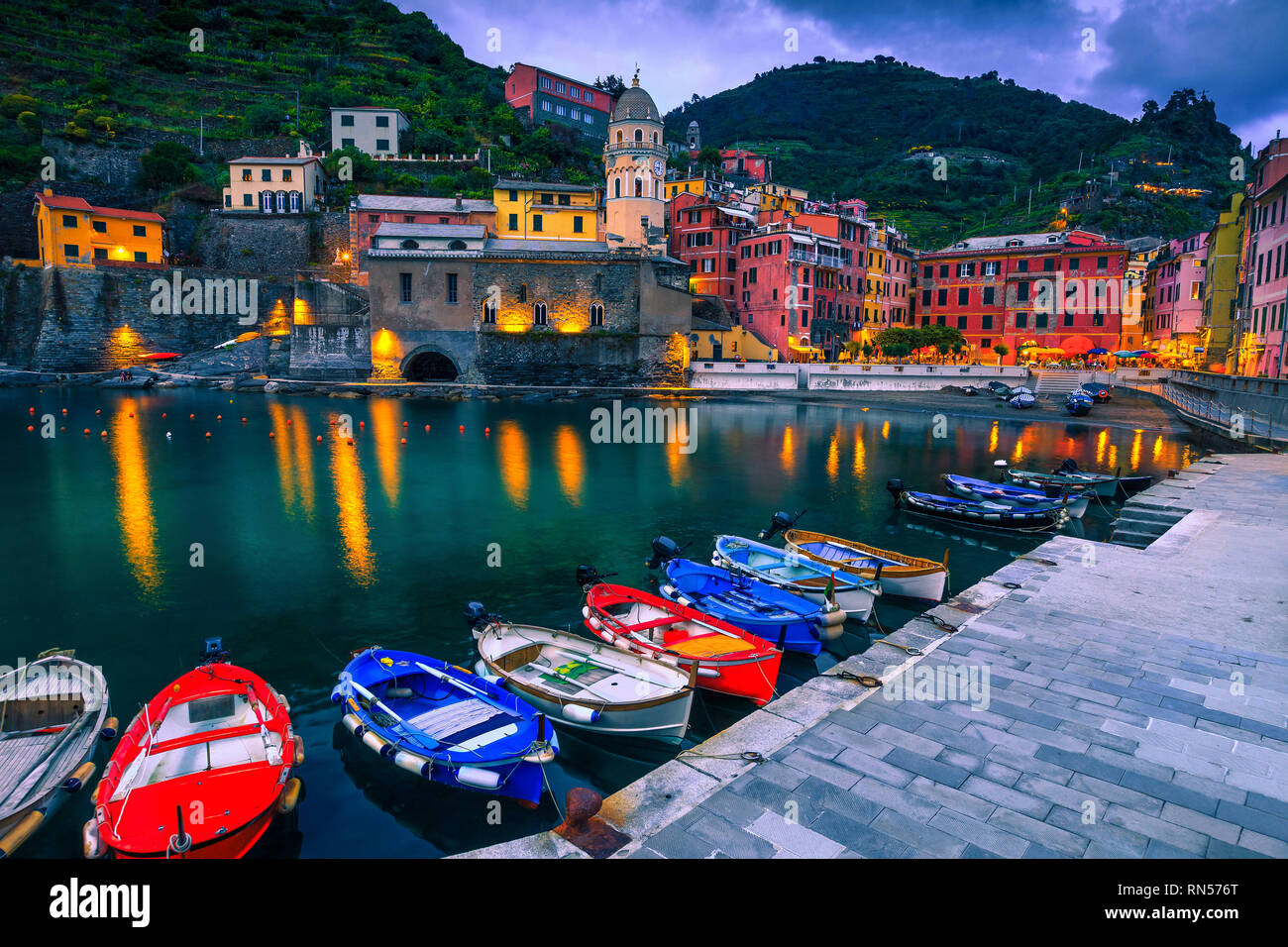 Fantastic travel and touristic destination. Amazing cityscape at evening with colorful mediterranean buildings and wooden fishing boats in harbor, Ver Stock Photo
