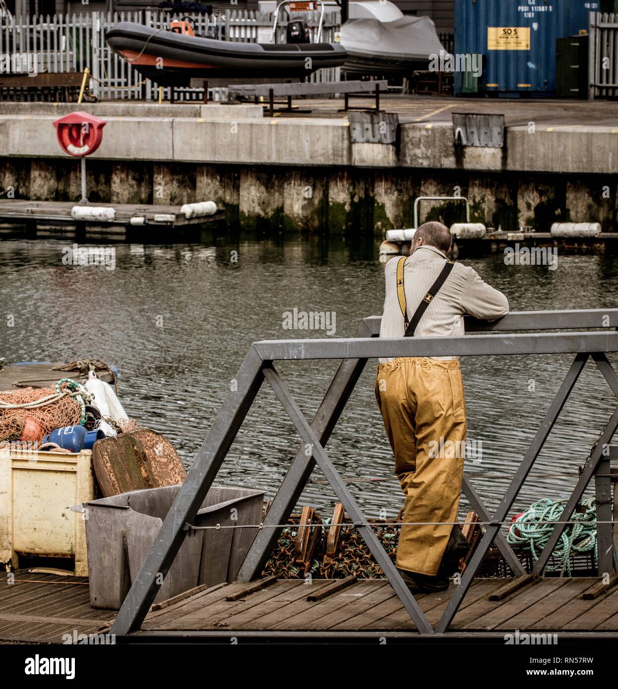 Trawler fisherman resting on jetty Stock Photo